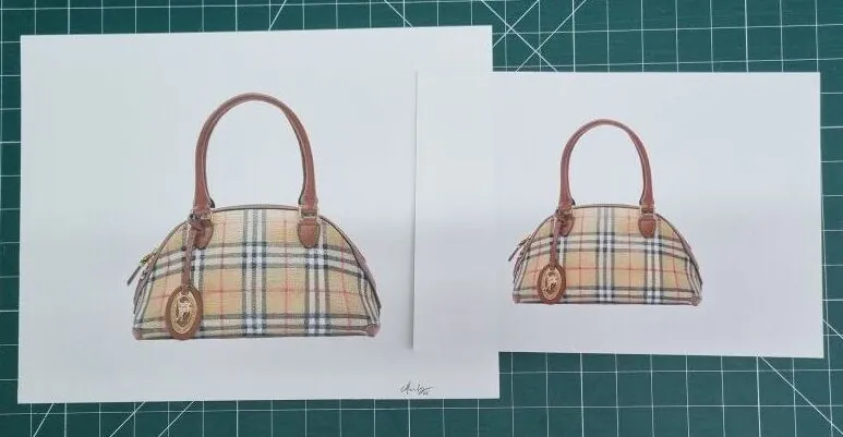 Two giclée prints of a tartan handbag illustration, side by side on the studio cutting mat