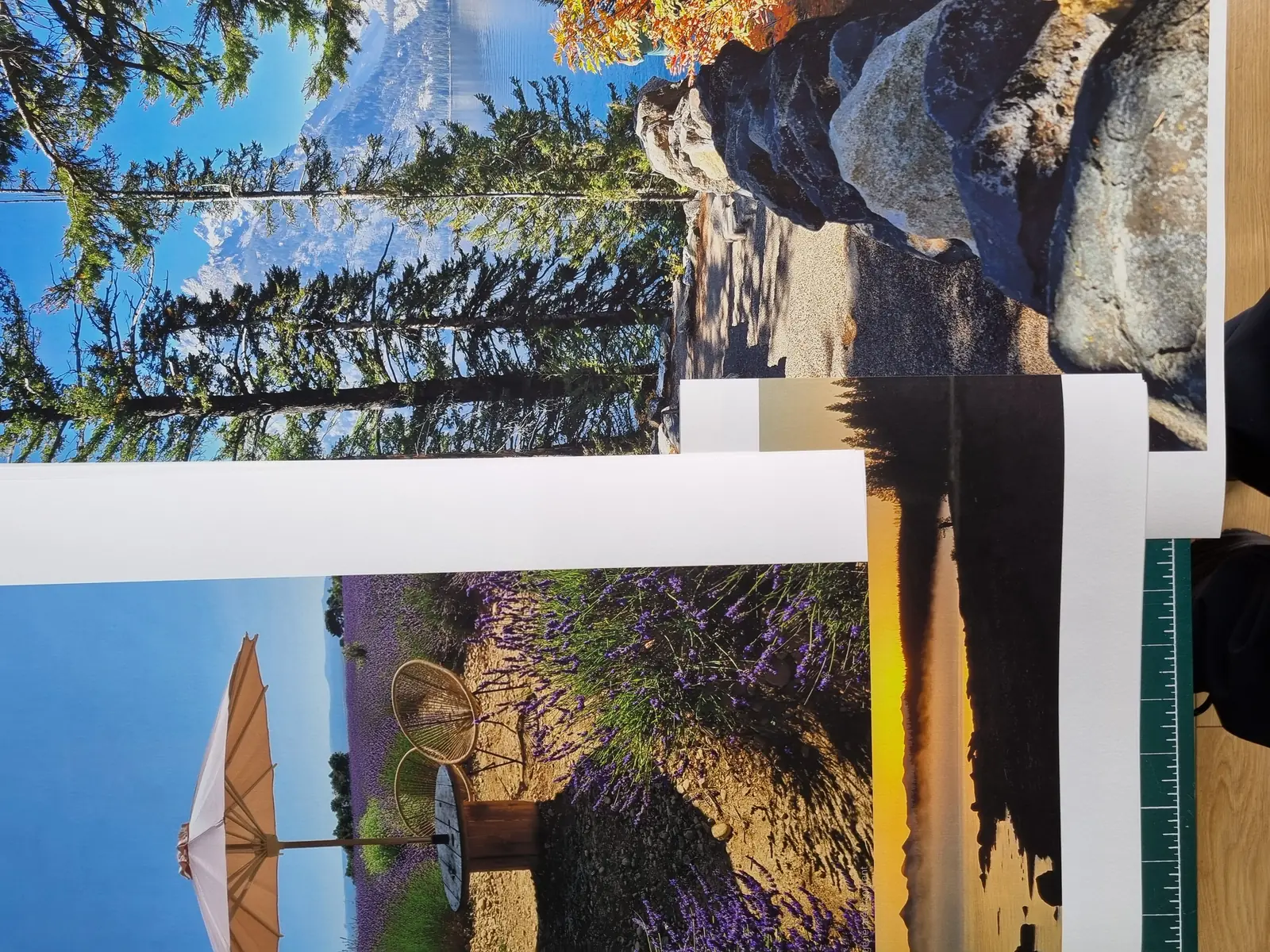 A stack of landscape photograph prints on the studio cutting mat